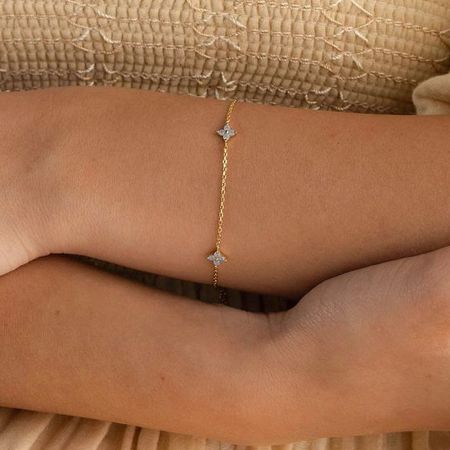 Close-up of the gold clover bracelet showcasing its fine details.