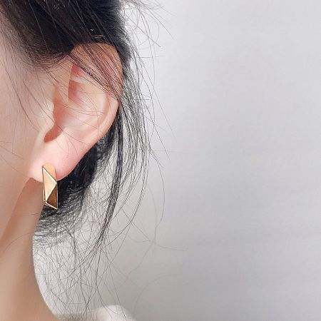 Close-up of the elegant gold-plated geometric hoop earring being worn.