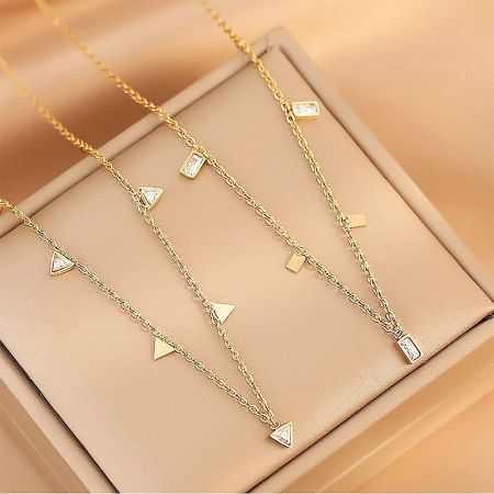 Three distinct geometric charm necklaces from the collection displayed together.