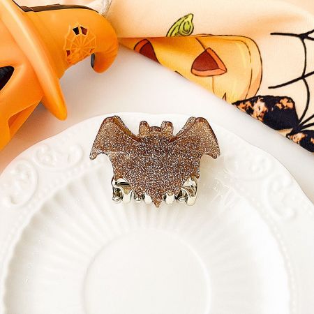 Elegant gold glittery bat-shaped hair clip.