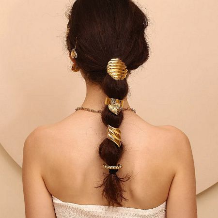 A model showcasing how the gold hair cuff elegantly styles a braided ponytail.