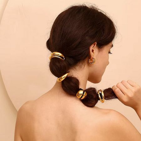 Close-up of the gold lip-shaped hair accessory securing a woman's ponytail.