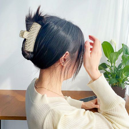 Close-up of the gold rhinestone hair clip securing a stylish bun, demonstrating its strong hold.