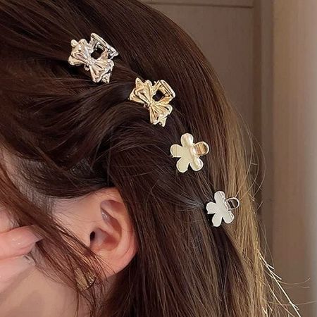 Close-up of gold bow and flower shaped mini hair clips.