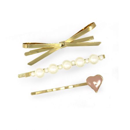 Close-up of three gold hair accessories: a bow-shaped clip, a pearl-studded clip, and a heart-decorated clip.