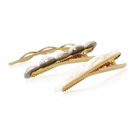 Detailed shot of two gold hair clips with elegant pearlescent designs.