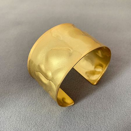 Detailed view of the gold hammered cuff bracelet, showcasing its artisanal finish.