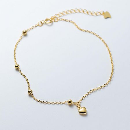 Close-up view of the 18K gold-plated heart charm bracelet, highlighting the bead details.