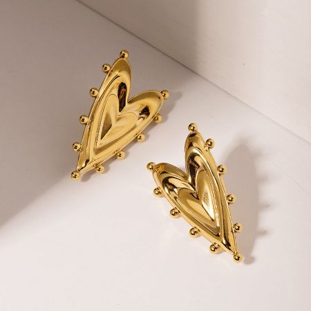 A detailed studio shot of the gold heart earrings highlighting their smooth, shiny finish.