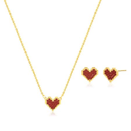 Close-up view of the gold heart jewelry set with red gemstones.