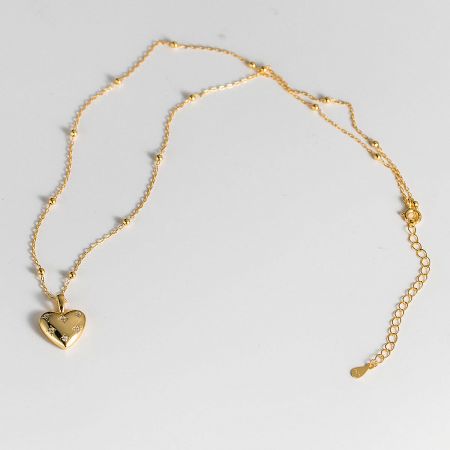 Detailed view of the gold-plated heart pendant necklace with shimmering cubic zirconia.