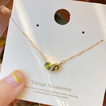 The green emerald heart necklace displayed on a professional jewelry card.
