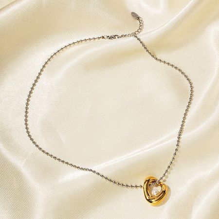 Gold necklace featuring an interlocking hearts pendant with a pearl.