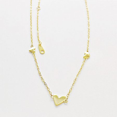 Close-up of the triple heart pendant design in gold finish.