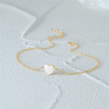 Detailed product shot of the gold heart pendant bracelet, highlighting the chain and clasp.