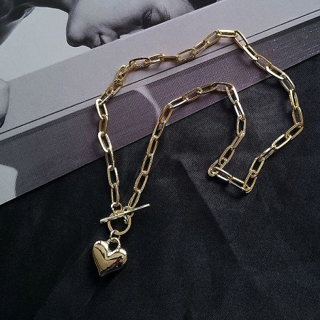 Side view of the gold chain necklace showcasing the heart pendant's thickness.