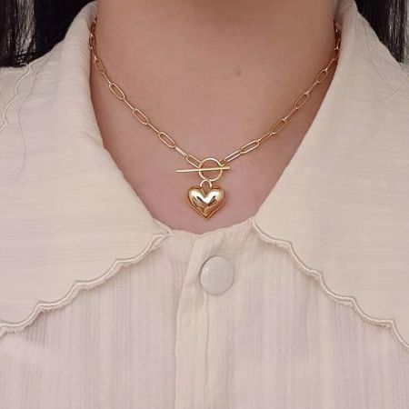 Detailed shot of the gold heart pendant on its chain.