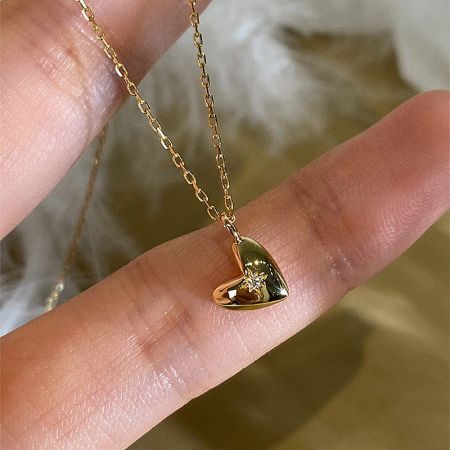 A clear product shot of the 925 sterling silver heart necklace with 18K gold plating.