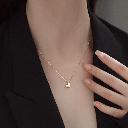 Model showcasing the chic gold heart pendant necklace.