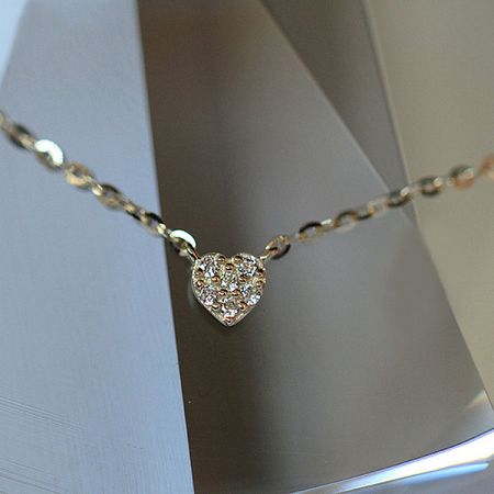 Detailed view of the gold 925 sterling silver heart pendant with sparkling cubic zirconia stones.