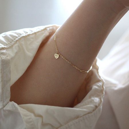 A delicate gold-plated sterling silver bracelet with a simple heart charm.