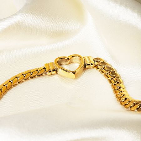 Elegant gold bracelet featuring a prominent heart-shaped clasp.