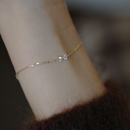 S925 Gold Elegant Bowknot Cable Chain Bracelet Set of 5 - A close-up of the S925 gold elegant bowknot cable chain bracelet worn on a wrist, highlighting its delicate design and sterling silver material.