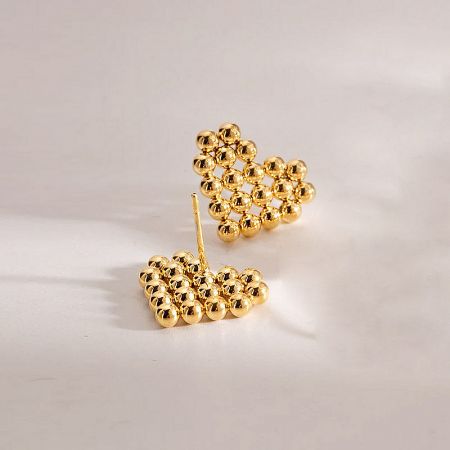 Detailed product shot of the gold heart-shaped earrings made of clustered beads.