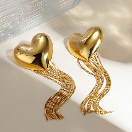 Full view of the elegant gold heart-shaped earrings with long, flowing chain tassels.