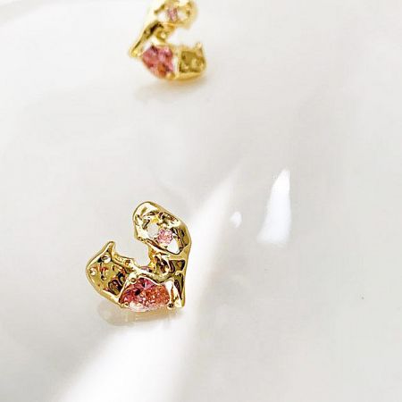 A pair of heart-shaped earrings showcasing the pink and white gemstones.