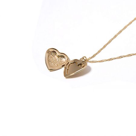 Close-up detail of the gold heart-shaped locket, showing its openable design and engraved interior.