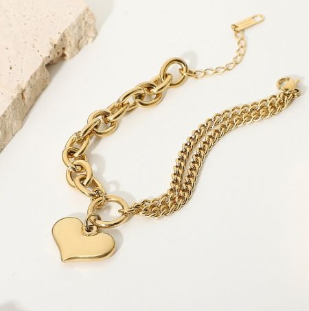 Detailed view of the puff heart links on the gold chain bracelet.