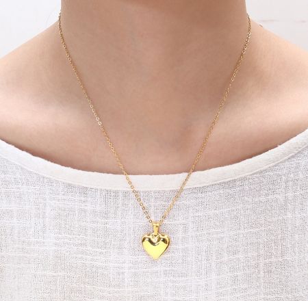 Model wearing the elegant gold heart-shaped pendant necklace from the stainless steel jewelry set.