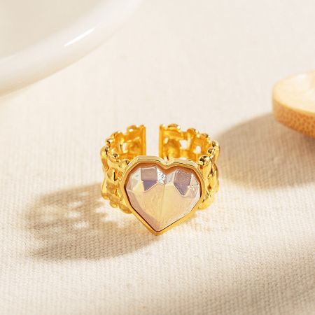 Side view of the gold mermaid heart ring with a pinkish-beige gemstone.