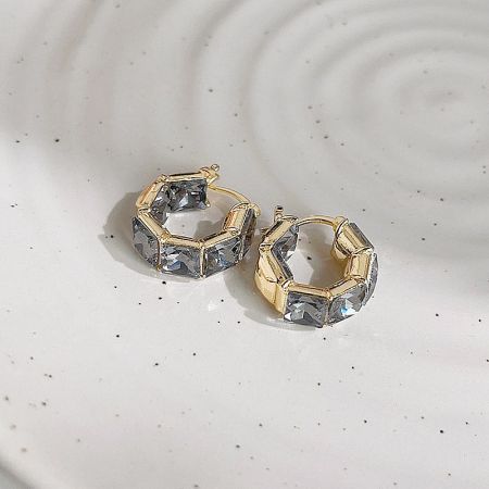 A pair of gold earrings featuring hexagonal clear gemstones.