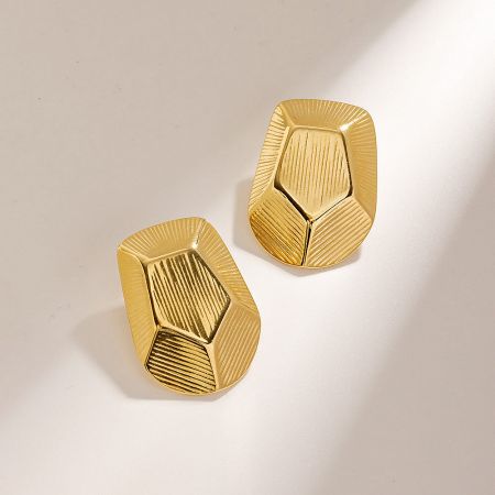 A pair of gold geometric pentagon stud earrings with a striped texture.