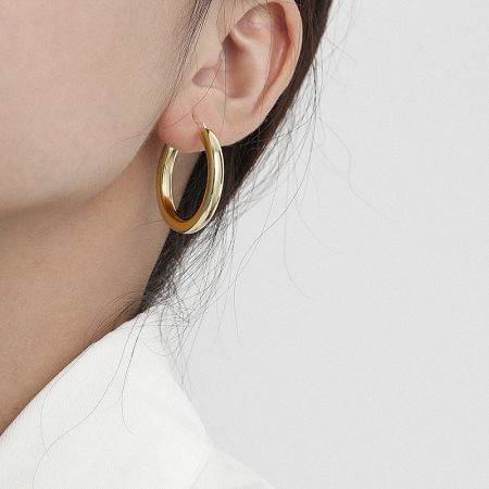 A model wearing the 18K gold-plated small thick hoop earring, demonstrating its chic and modern look for daily wear.