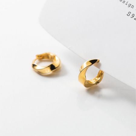 A pair of the gold 925 sterling silver hoop earrings shown from a side angle.