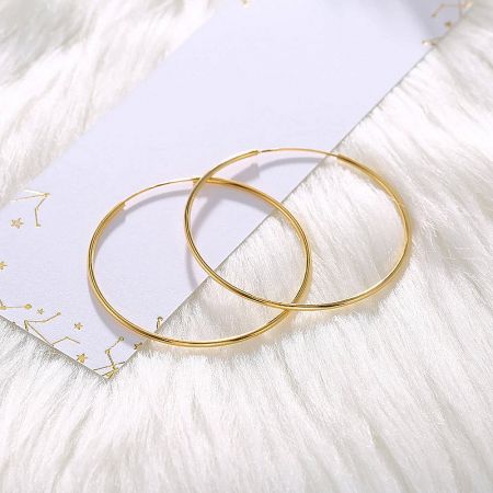 Product display of the 50mm hoop earrings in a radiant gold finish.