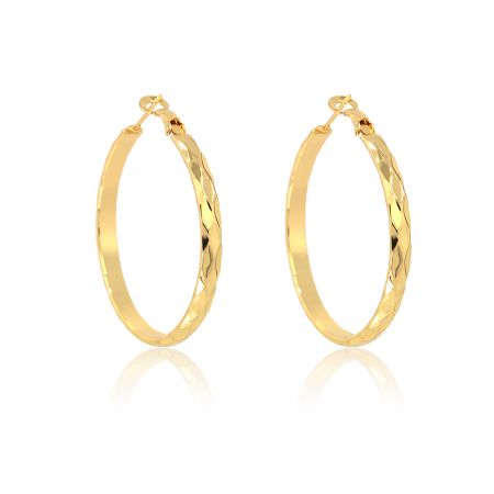 Close-up view of the gold hoop earring's textured, diamond-cut surface.