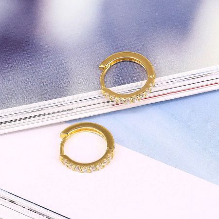 Detailed view of the gold-plated sterling silver hoop earrings with sparkling clear zircon stones.