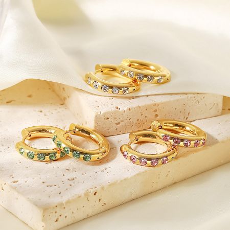 Multiple pairs of the stainless steel hoop earrings displaying the range of available gemstone colors.