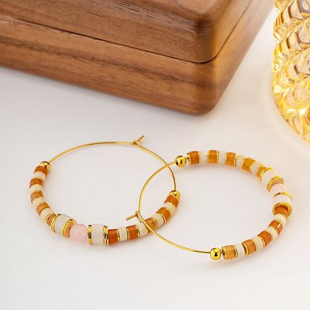 A pair of gold hoop earrings with a vibrant mix of orange, white, and pink beads.
