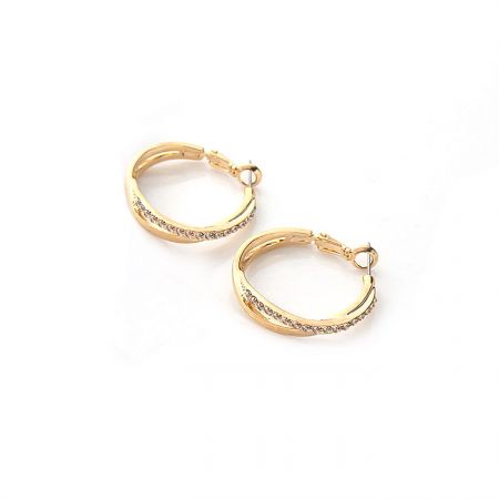 Detailed shot of the crystal embellishments on the gold hoop earrings.