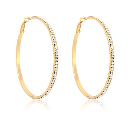 A pair of large gold hoop earrings with sparkling rhinestones displayed on a white surface