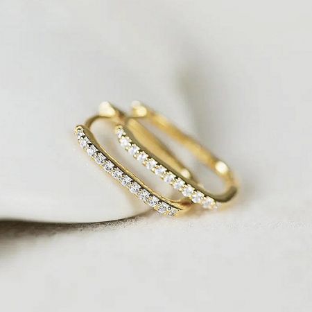 Detailed view of the gold huggie hoop earring showcasing the embedded diamonds.