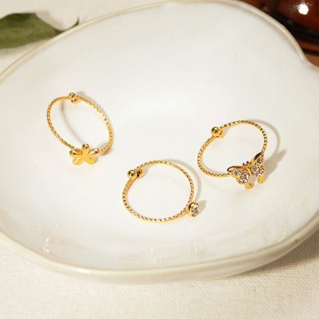 The intricate flower and butterfly designs on the gold-plated adjustable rings.