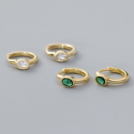 Four gold-plated huggie hoop earrings displayed, showcasing white and green gemstone options.