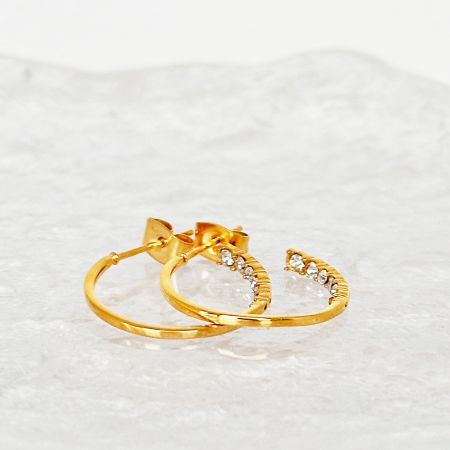 Close-up detail of the zirconia gemstones on the C-shape hoop earrings.