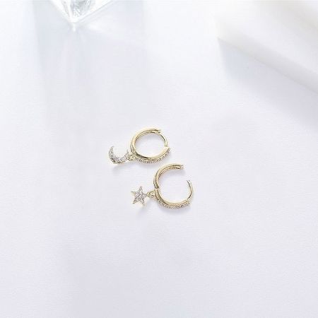 Another angle of the celestial-themed huggie earrings, showing the delicate moon and star dangles.